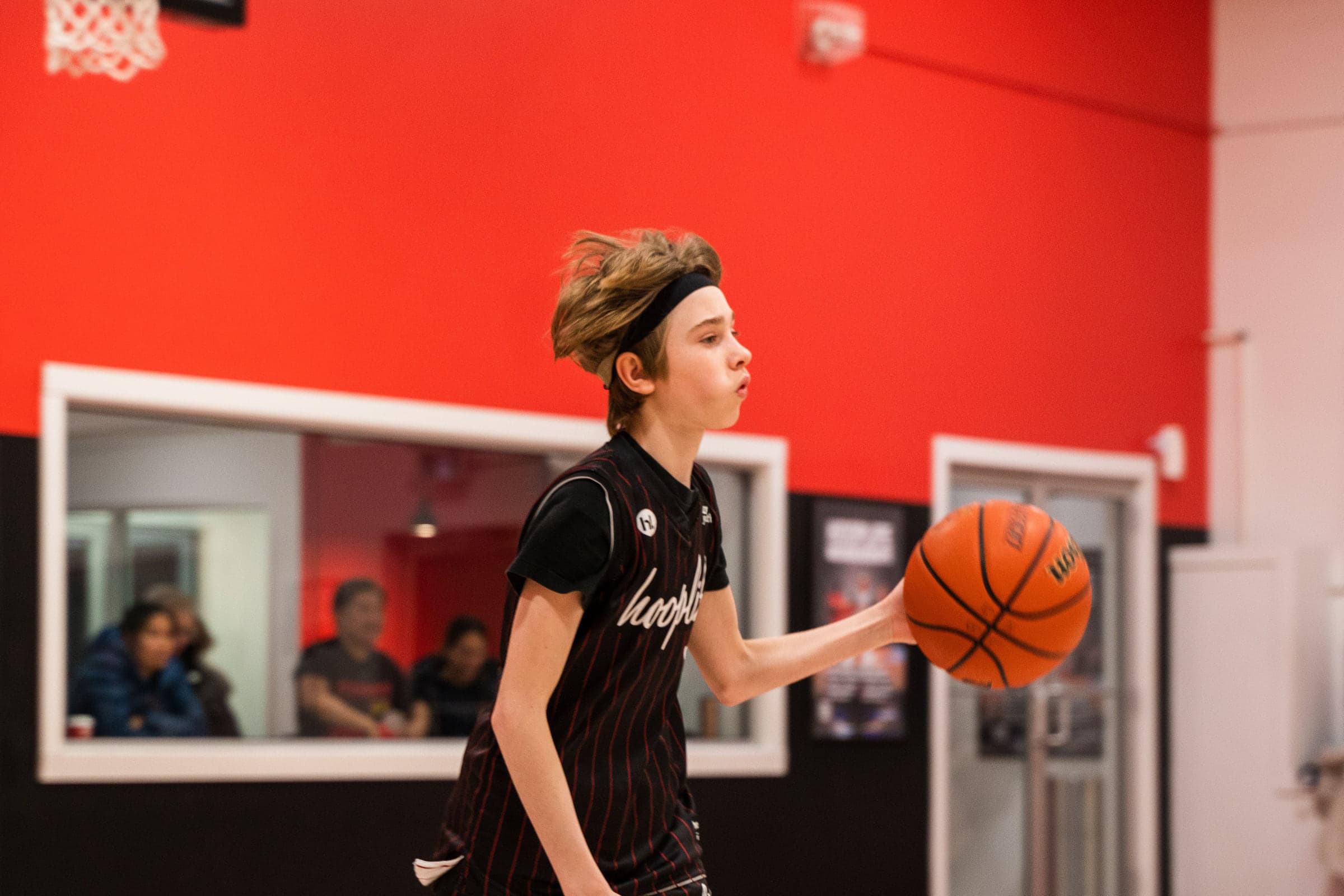 A young player attacking the rim during a HoopLife League game in Regina