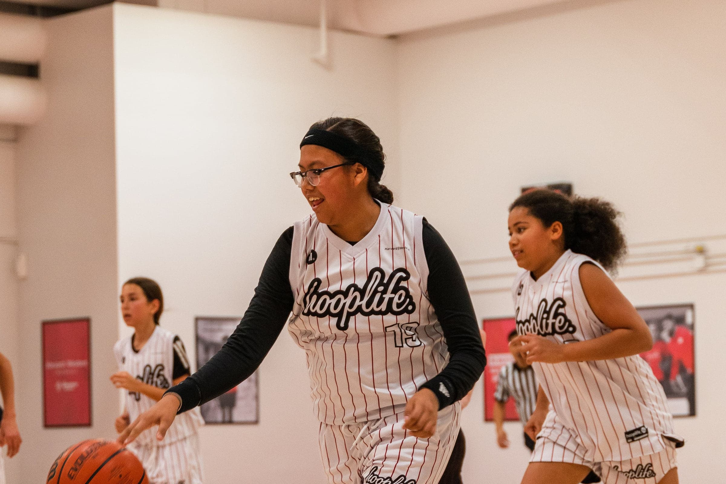 HoopLife League players moving with the ball during a game in Regina