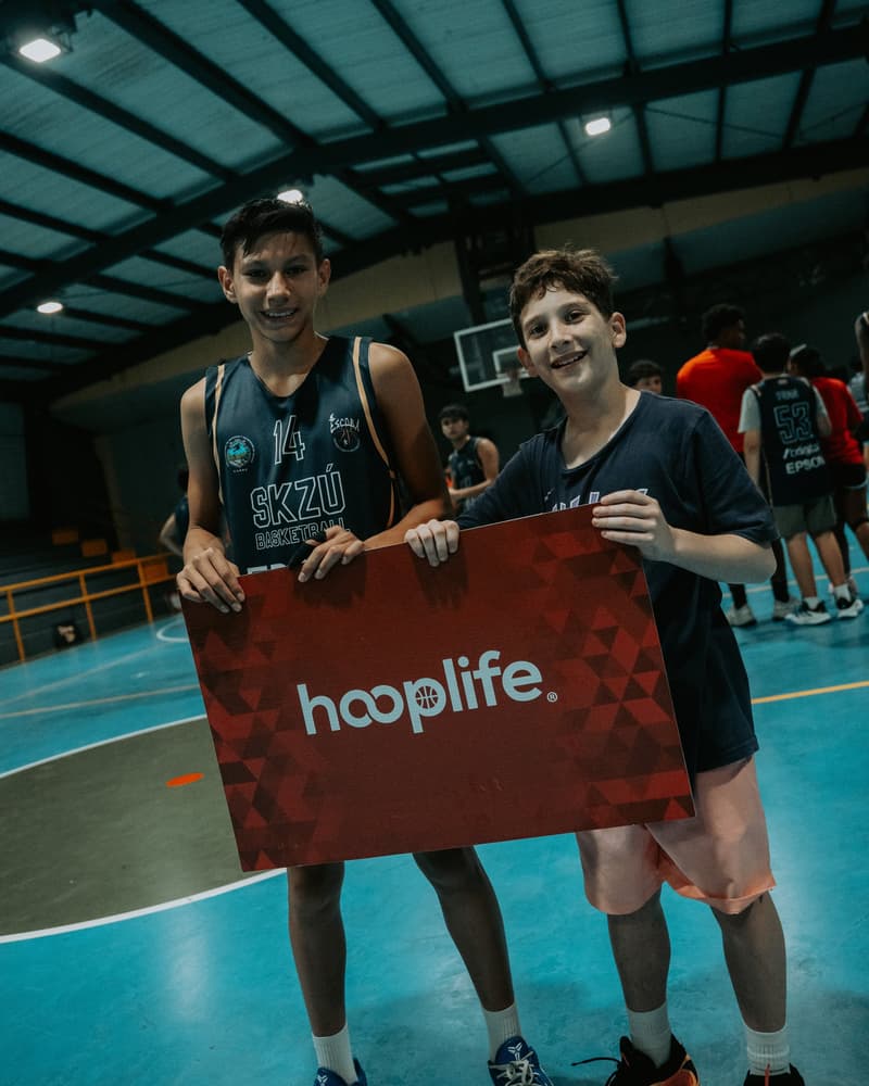 Two young players holding the HoopLife sign at the Costa Rica clinic