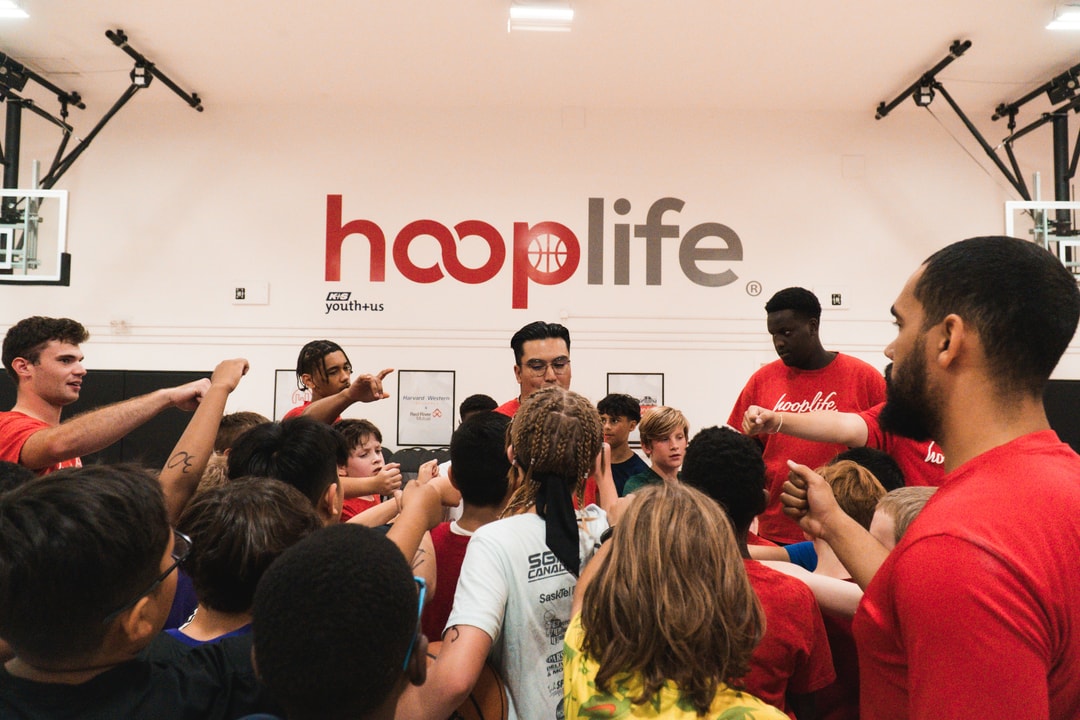 HoopLife coaches and a full camp group huddled together under the HoopLife wall in Regina