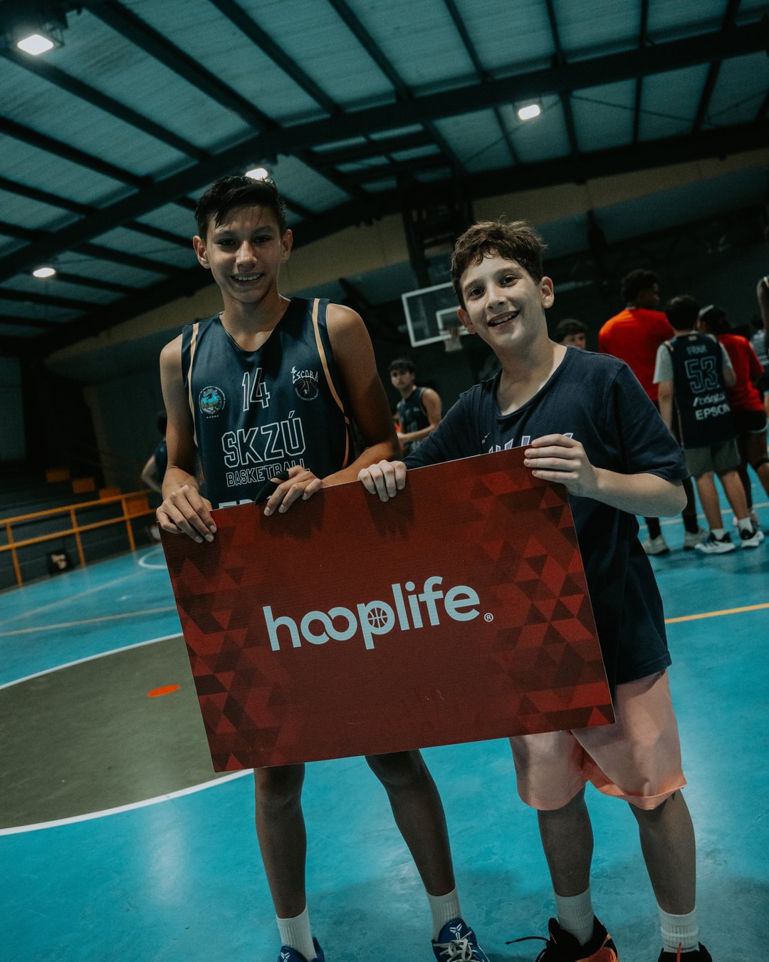Two young players holding the HoopLife sign at the Costa Rica clinic