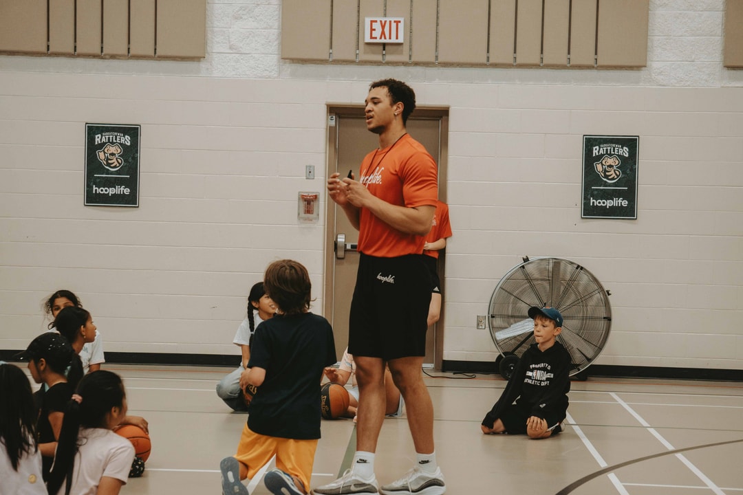 A HoopLife x Saskatchewan Rattlers community camp with partner posters on the doors