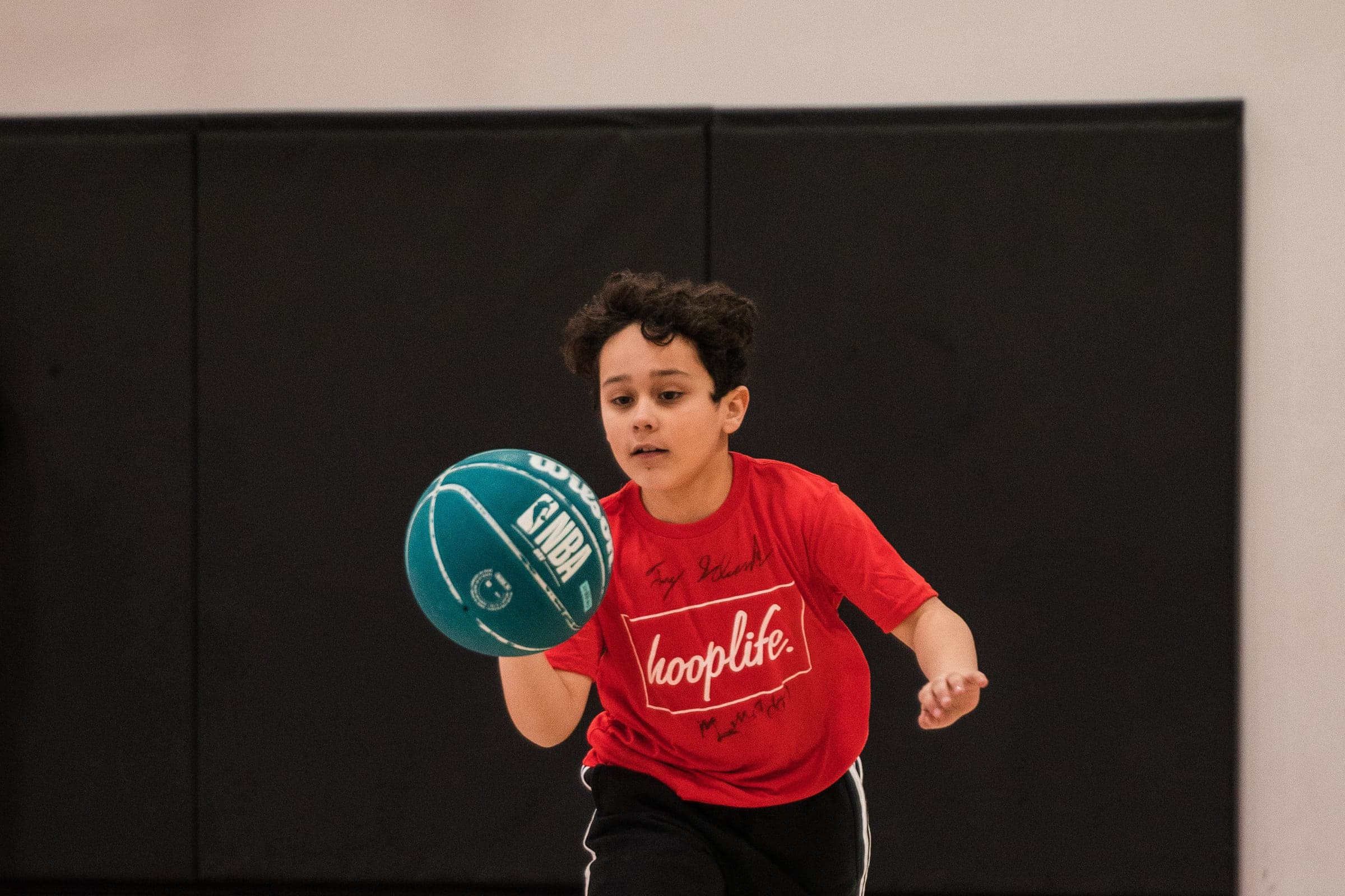 A first-time player dribbling in a HoopLife shirt at the HoopLife Centre in Regina