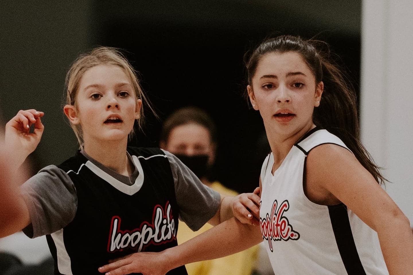 Two girls in HoopLife jerseys competing during a league game in Regina