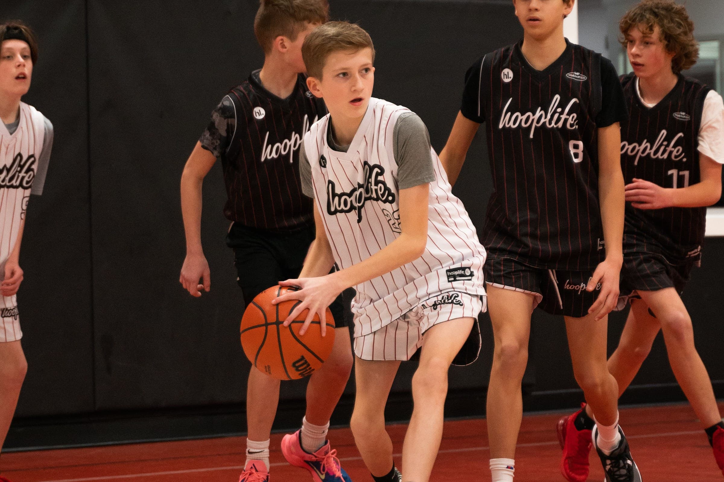 A HoopLife League player driving the ball in a real game at the HoopLife Centre in Regina
