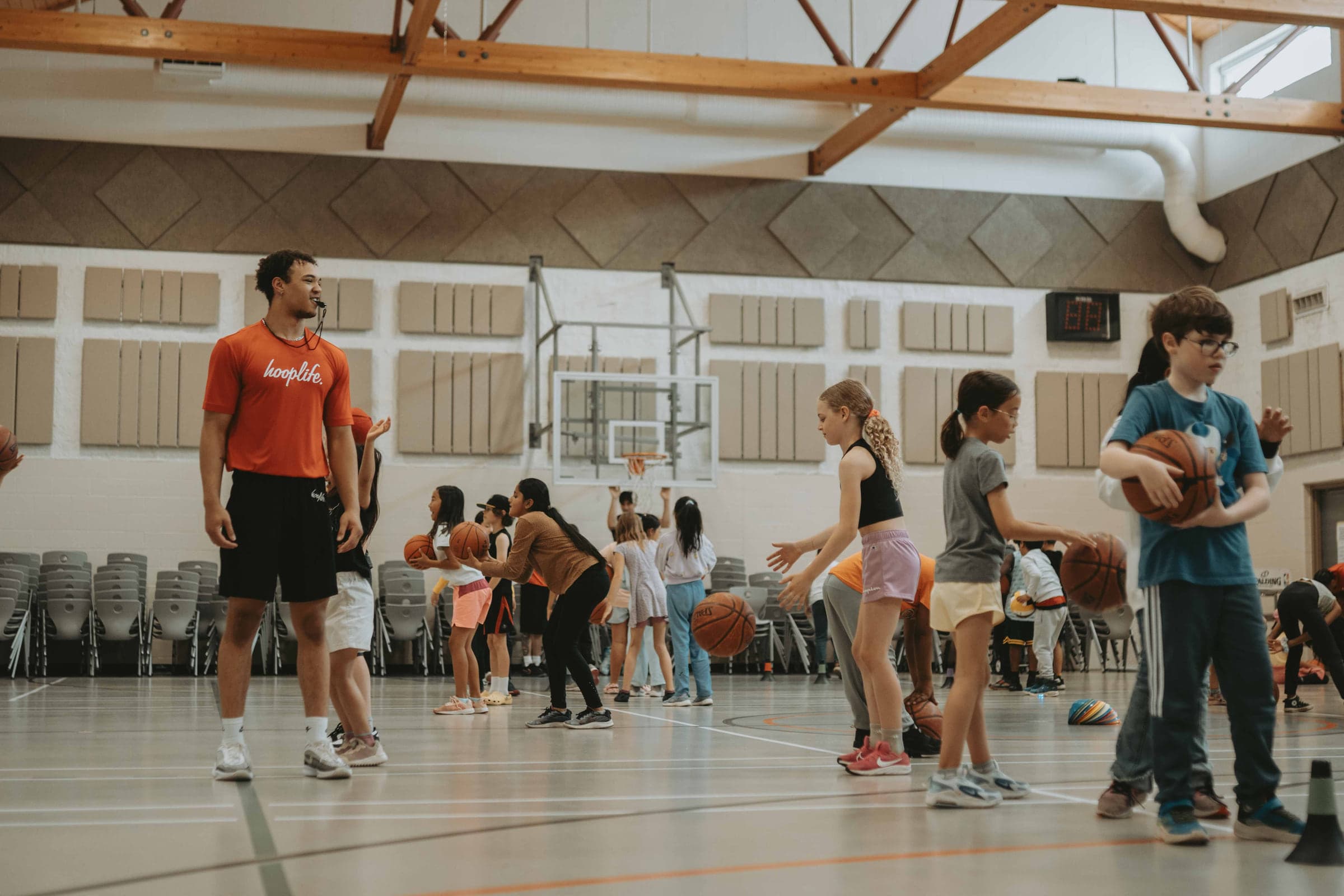 A HoopLife coach running a clinic in a community gym