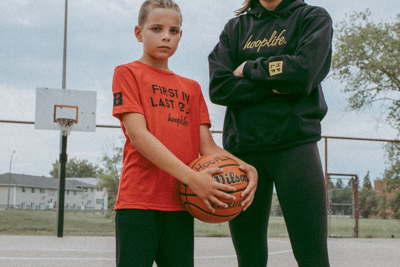 Two young people with a basketball outside after a HoopLife clinic