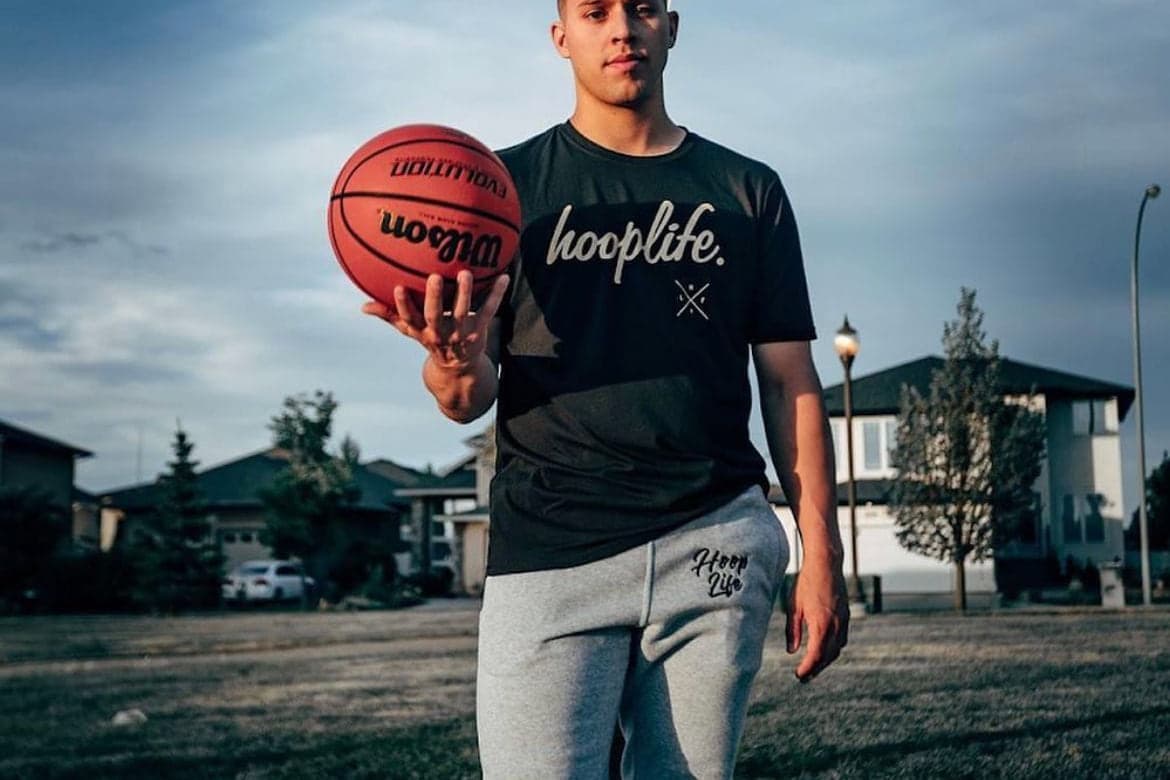 A player holding a basketball on an outdoor court in a Canadian community