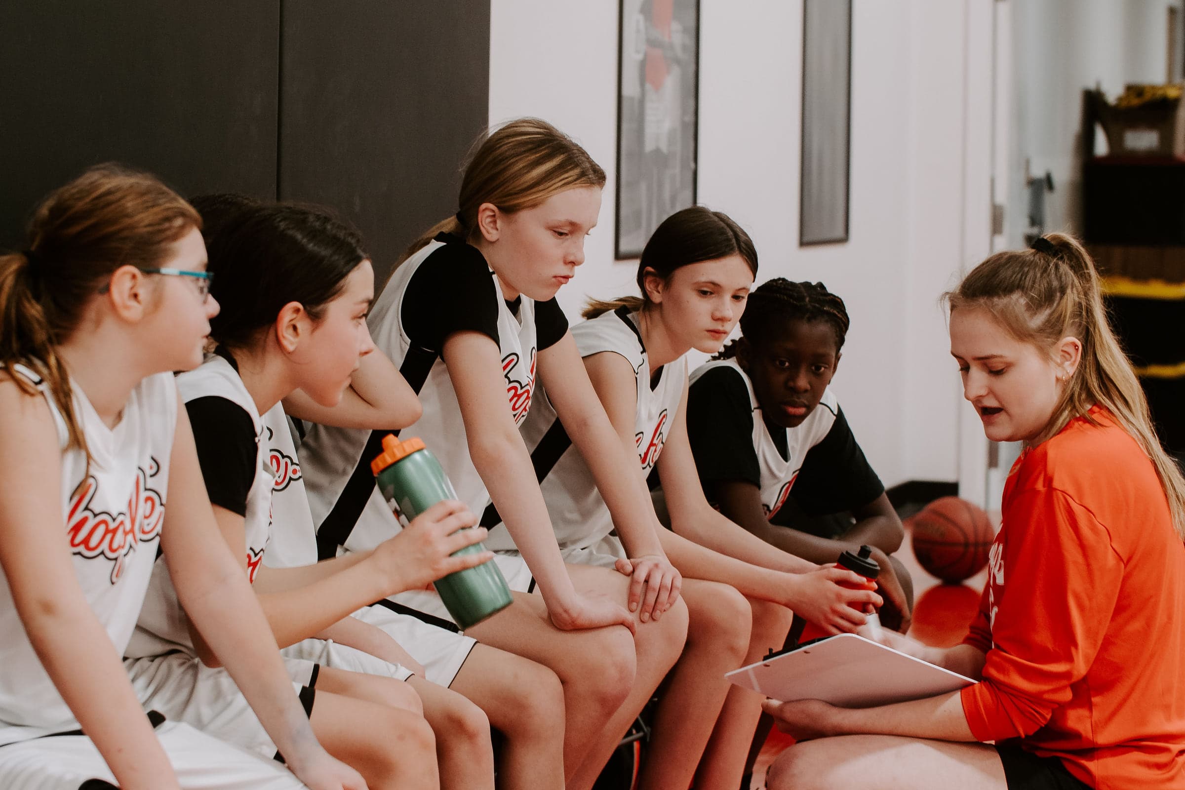 HoopLife players sitting together on the bench between games in Regina