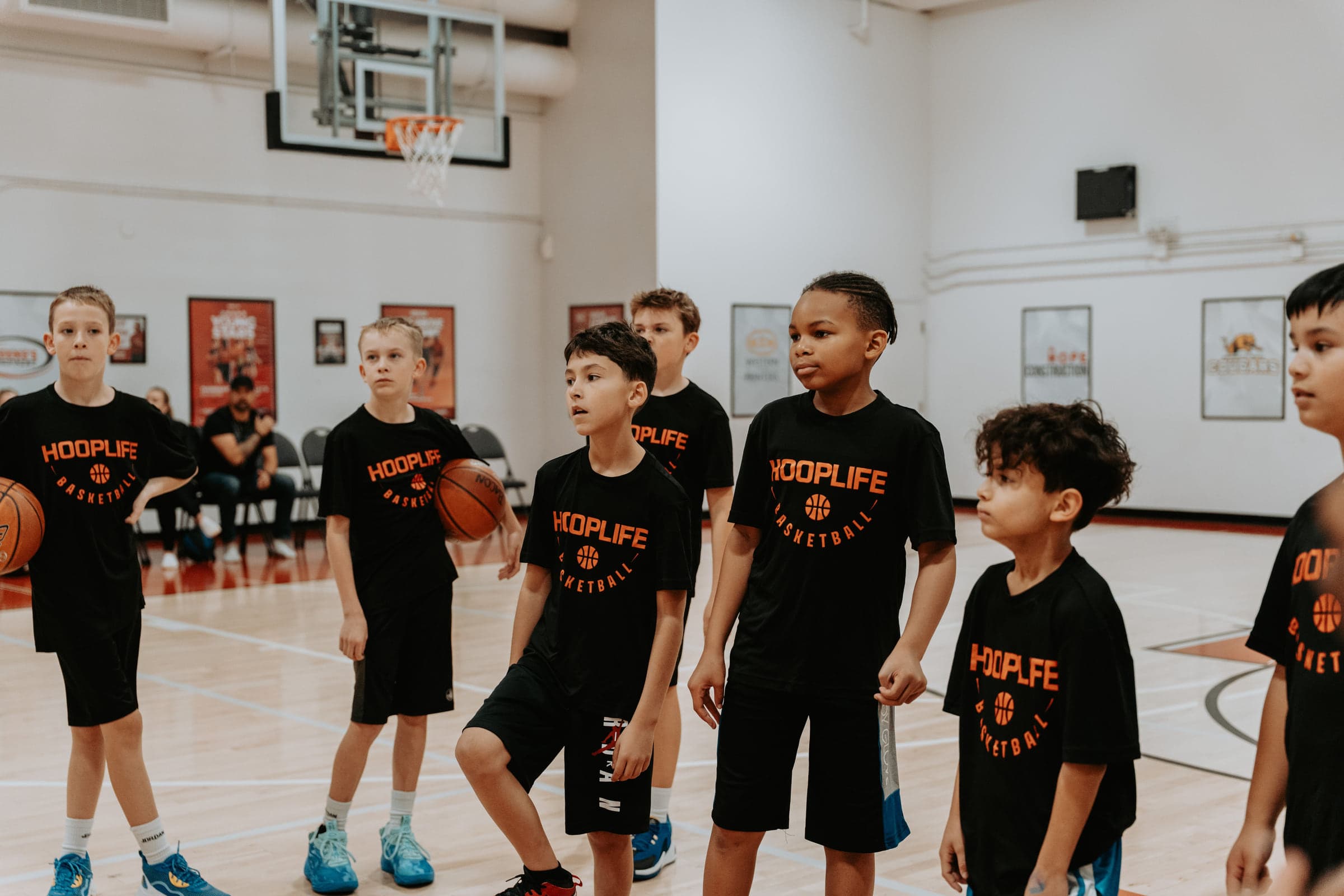A line of players in HoopLife shirts waiting their turn in a drill in Regina