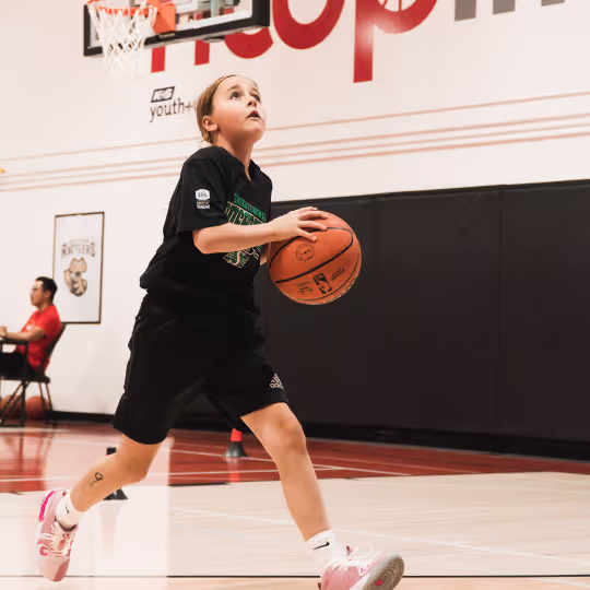 Female athlete running with basketball