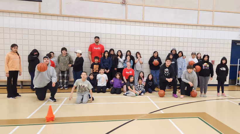 Kids and their coaches at a HoopLife travel clinic in a small-town gym