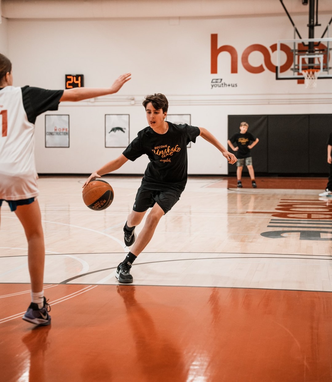 A young HoopLife player driving with the ball in a 3x3 game