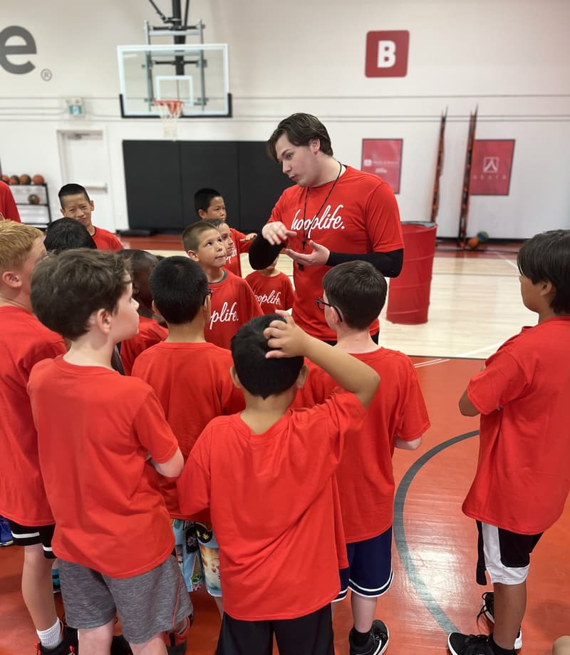A HoopLife coach with a group of Young Stars on the court