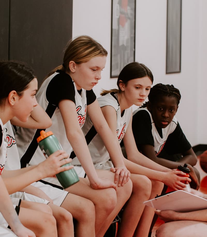 HoopLife players together on the bench between games