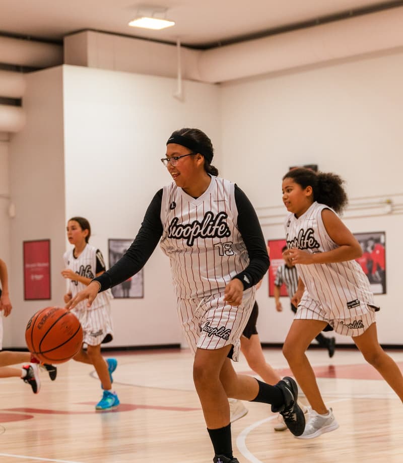 Girls playing live basketball at the HoopLife Centre in Regina