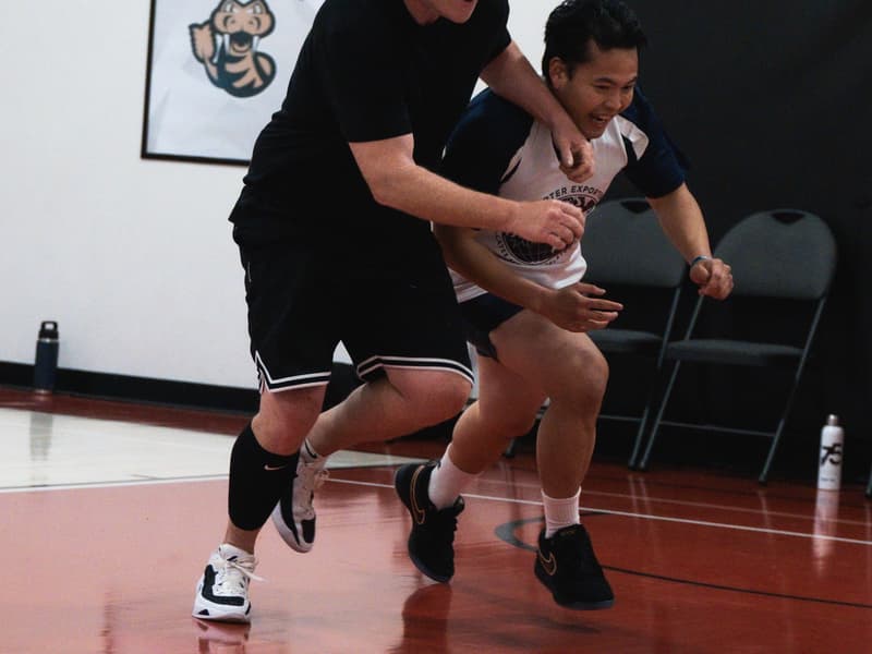 Adult league players chasing down a loose ball