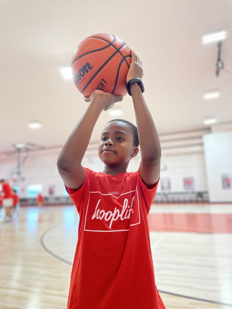 A camper in a red hooplife shirt lining up a shot