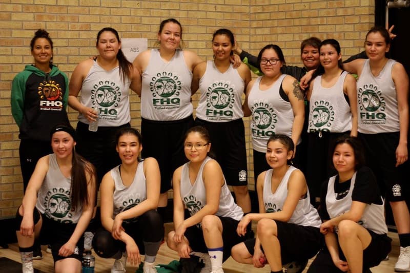 A girls team with their coaches at a HoopLife community event