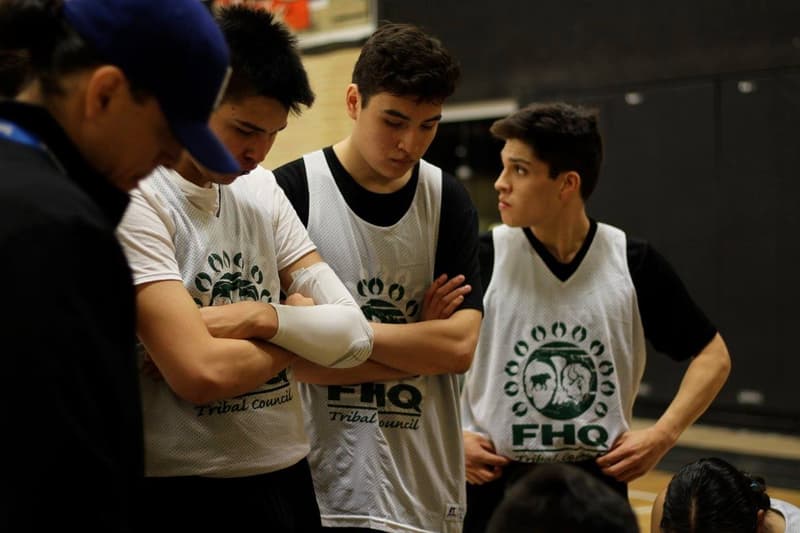 Teens listening in during a timeout team talk at a HoopLife event
