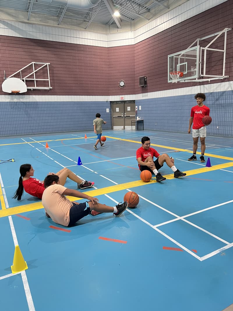 HoopLife coaches leading kids through a warm-up stretch at the Kawacatoose clinic