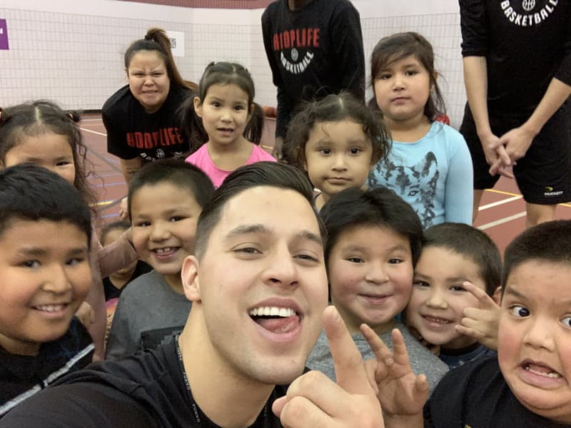 A HoopLife coach grabbing a selfie with laughing Kinistin campers