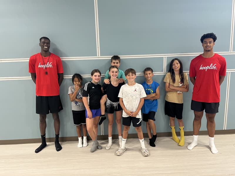 Two HoopLife coaches with smiling kids at a rec-centre clinic