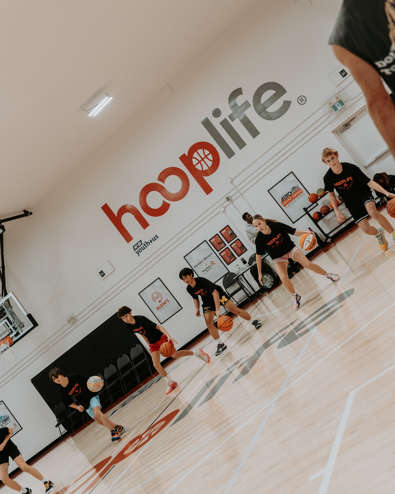 Players dribbling on the court under the hooplife wall at the HoopLife Centre in Regina