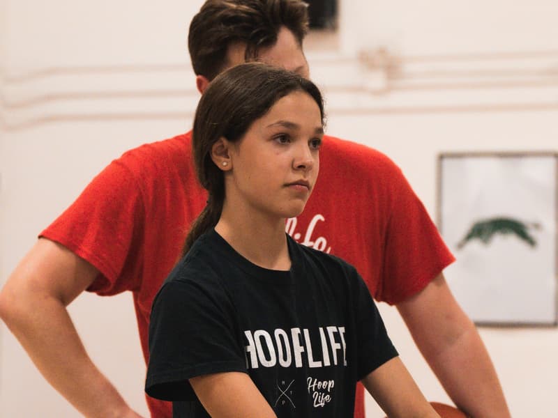 A coach rebounding for a member at open gym