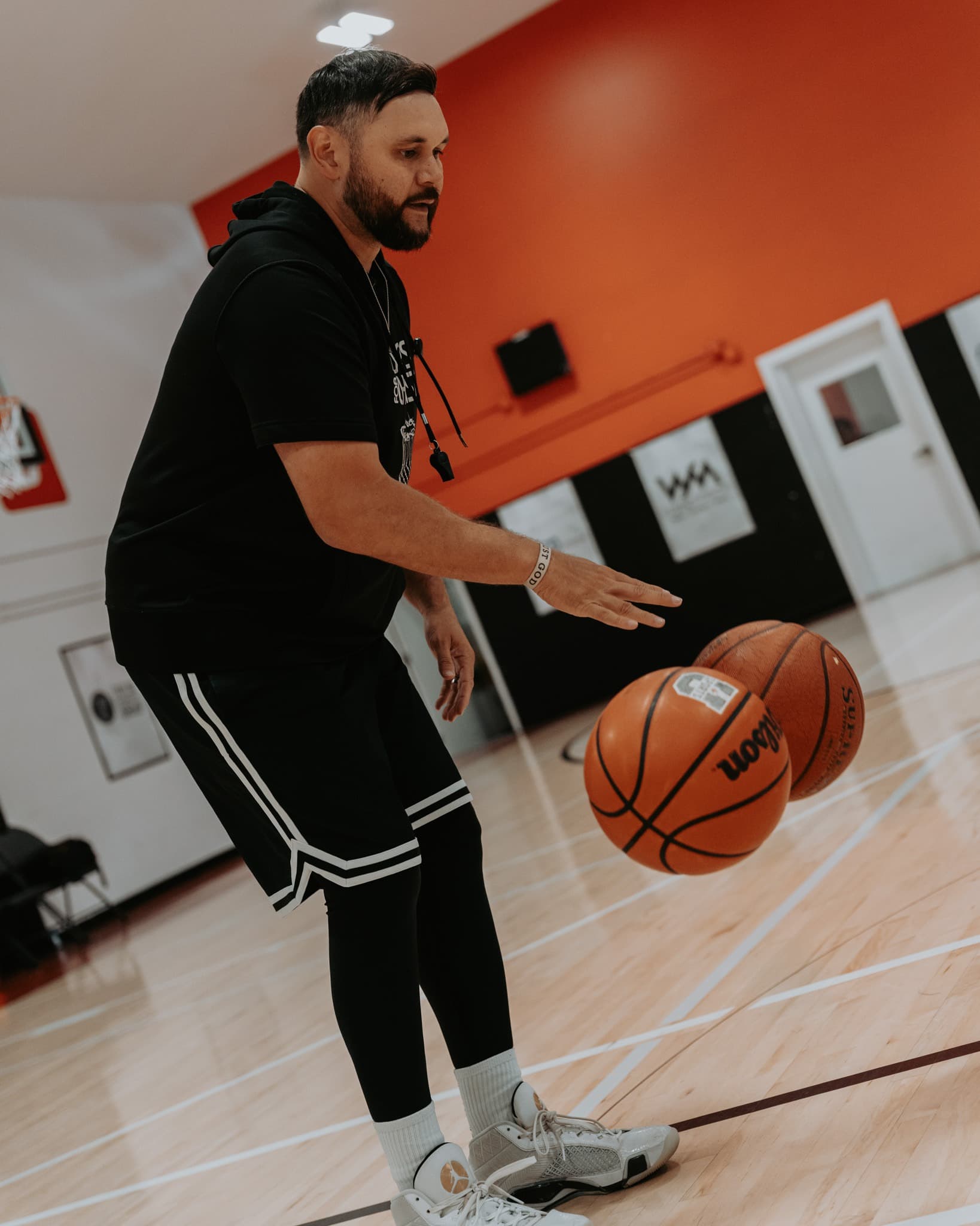 Phillip Morrison juggling two basketballs in a ball-handling demo