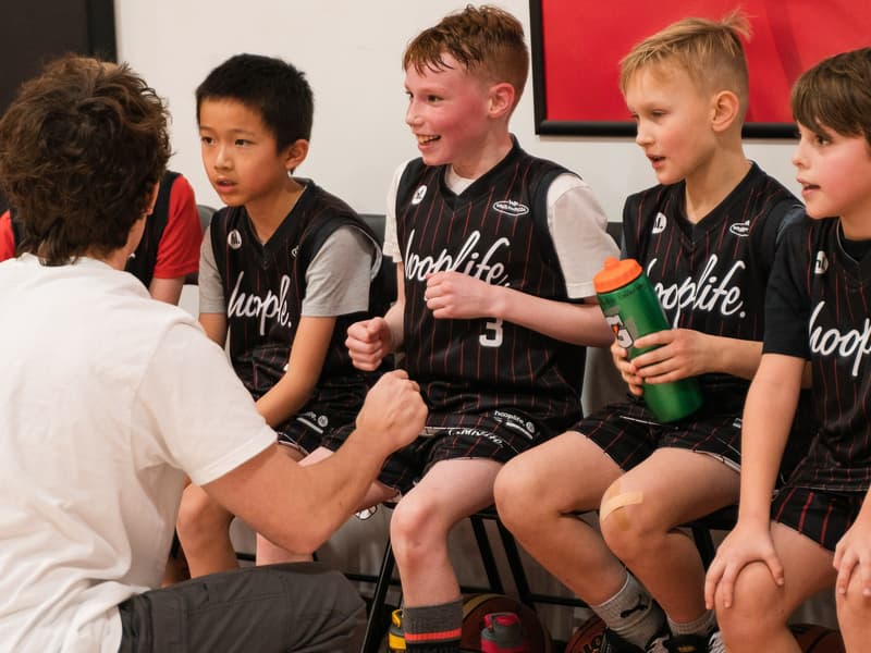 Teammates on the bench between drills at HoopLife