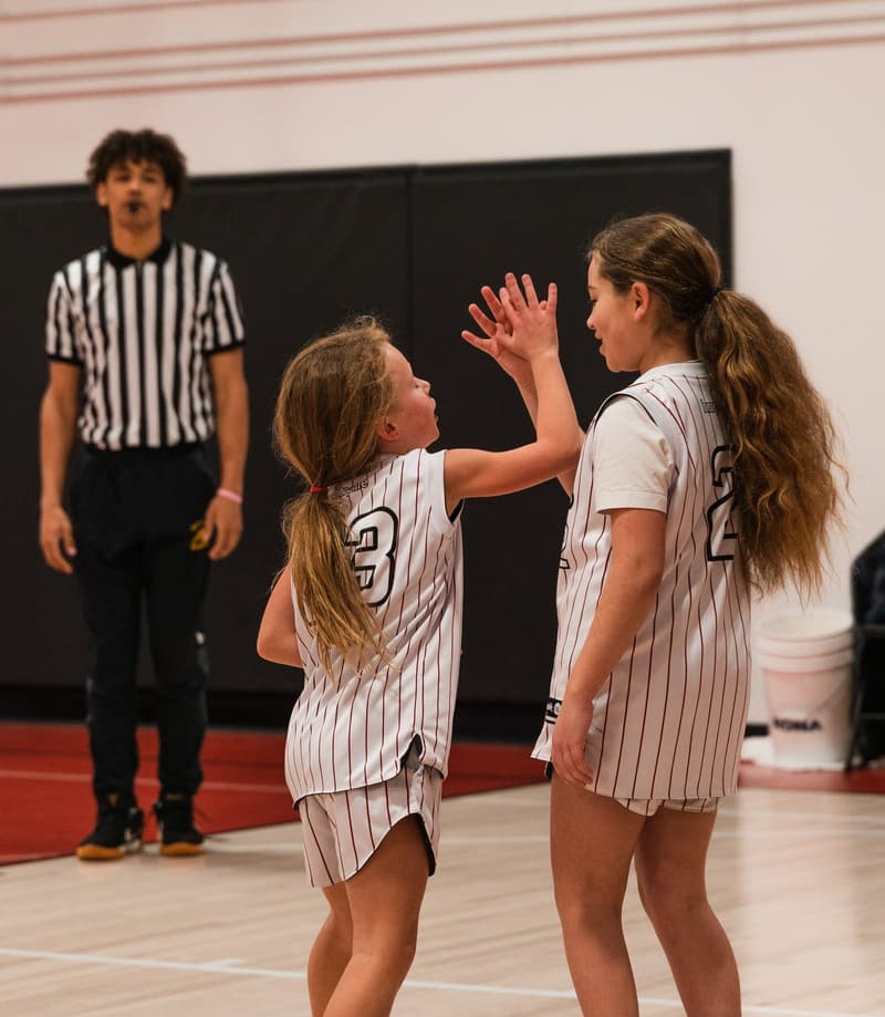 A girls game with a referee on the floor