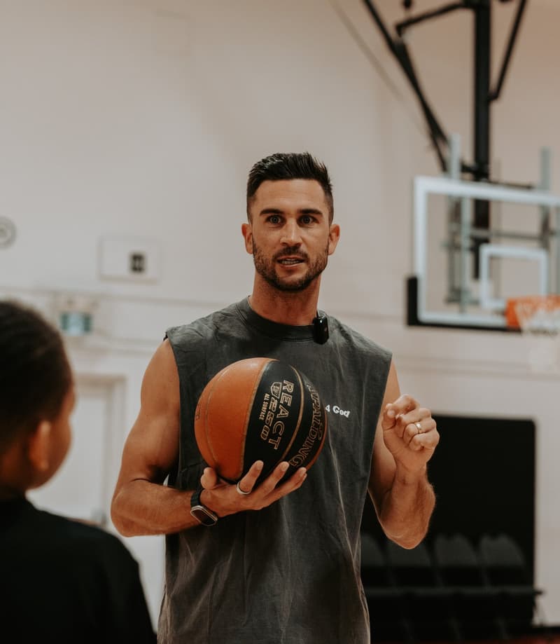 A HoopLife coach demonstrating shooting form to a player